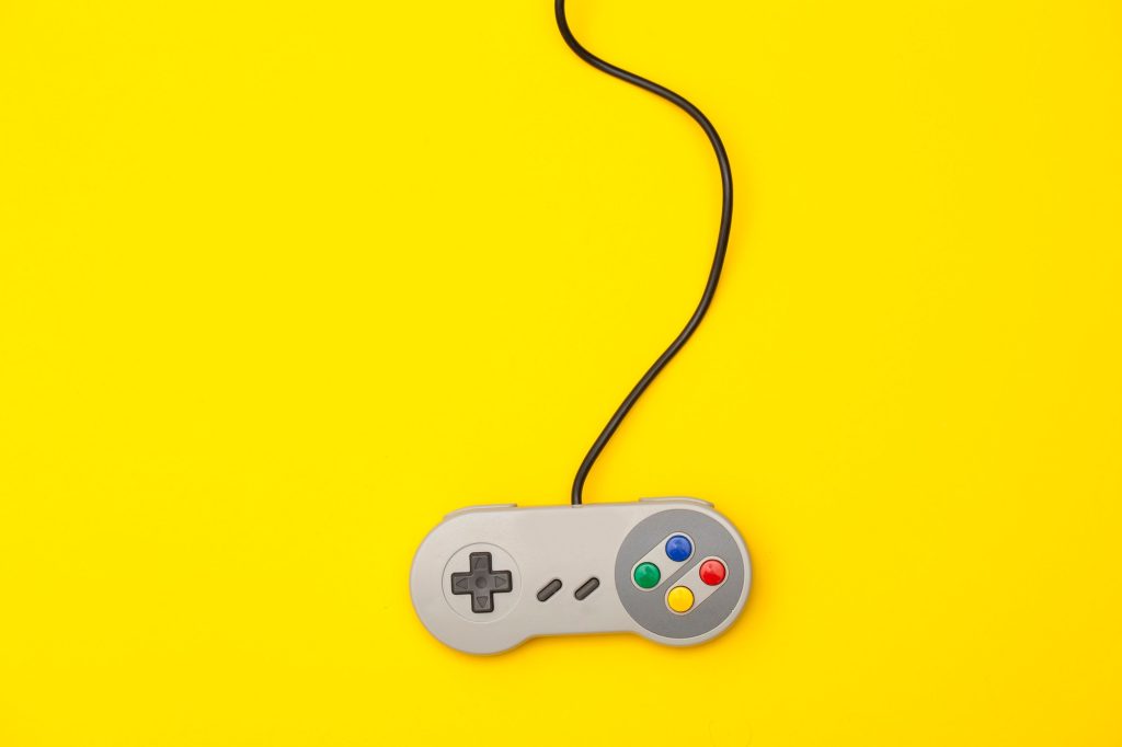 Retro computer gaming controller on a yellow background